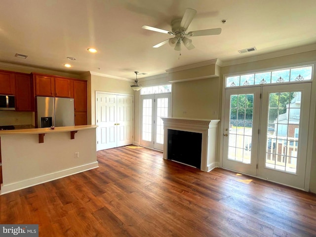 unfurnished living room with dark hardwood / wood-style flooring, a wealth of natural light, ornamental molding, and ceiling fan