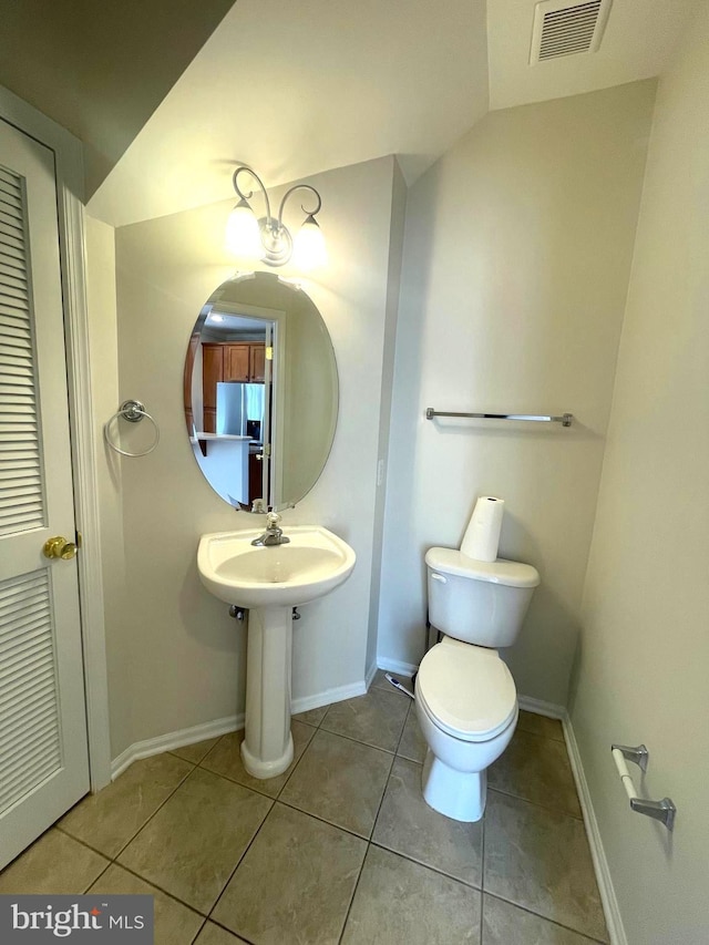 bathroom featuring tile patterned flooring, vaulted ceiling, and toilet