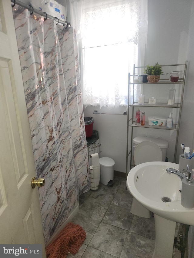 bathroom with sink, toilet, and tile patterned floors