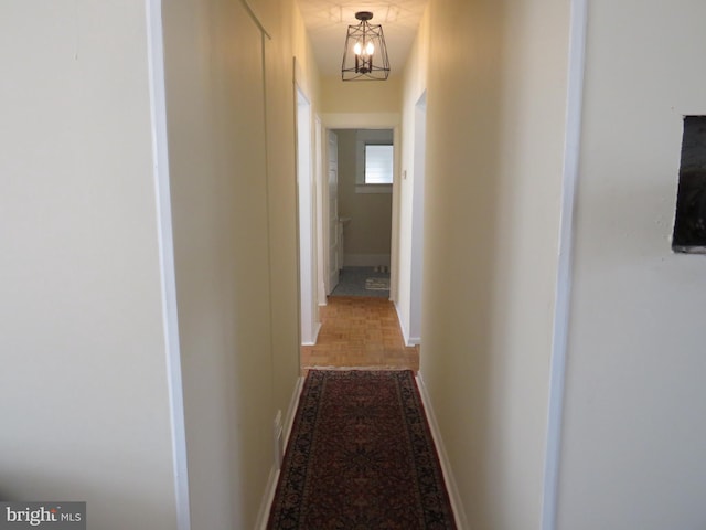 hall featuring parquet floors and a notable chandelier