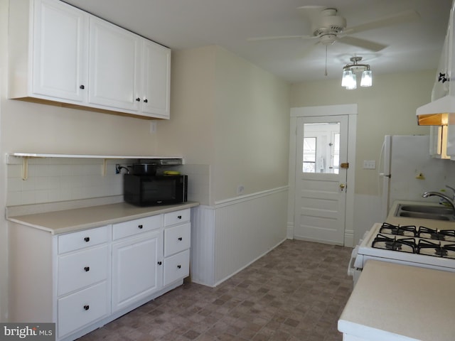 kitchen featuring sink, white appliances, white cabinets, ceiling fan, and exhaust hood