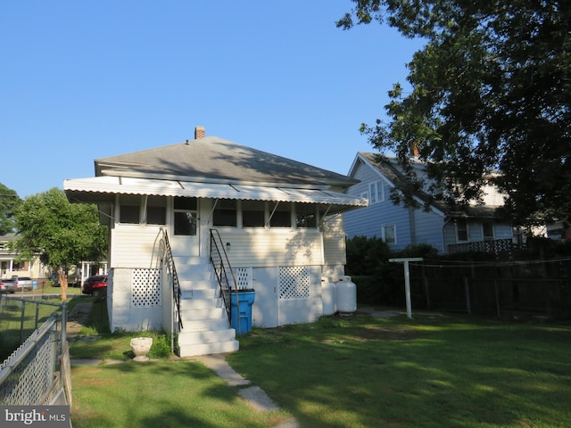 rear view of house featuring a yard