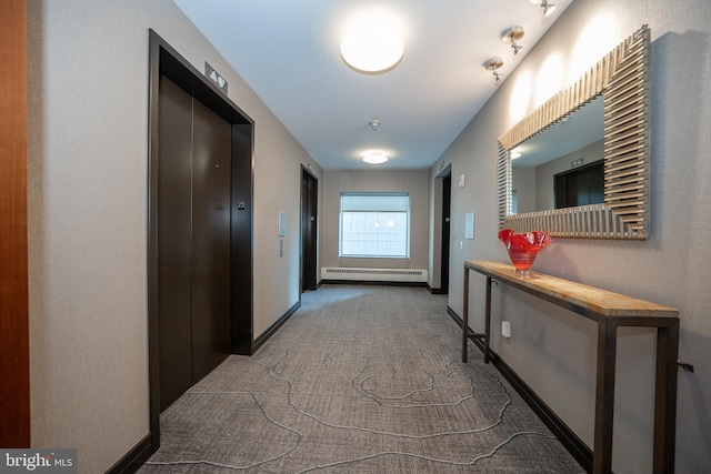 corridor with elevator, a baseboard radiator, and carpet