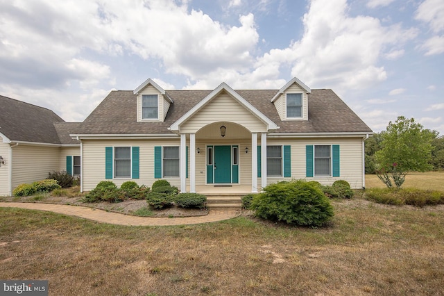 cape cod home with a porch and a front lawn