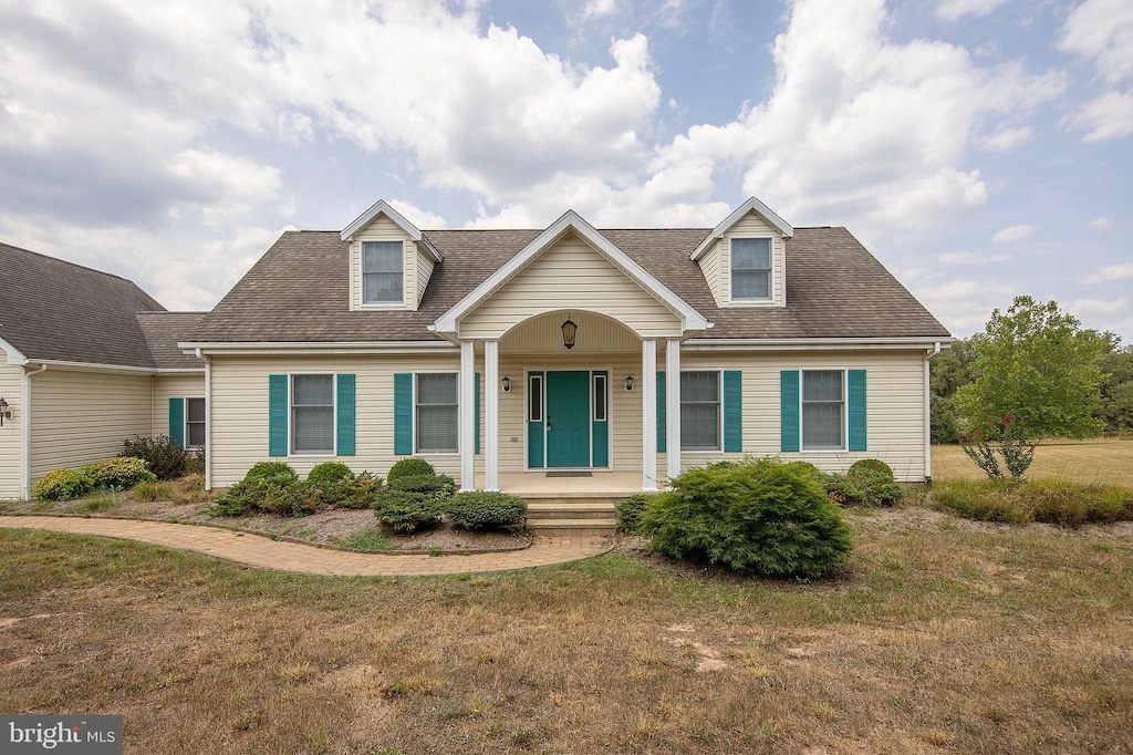 new england style home featuring a front lawn