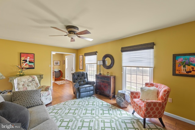 living room featuring ceiling fan, light hardwood / wood-style floors, and a wealth of natural light