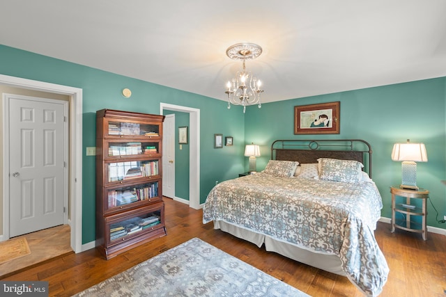 bedroom featuring hardwood / wood-style floors and an inviting chandelier