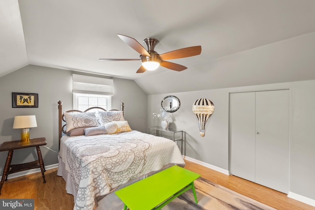 bedroom with hardwood / wood-style flooring, lofted ceiling, ceiling fan, and a closet