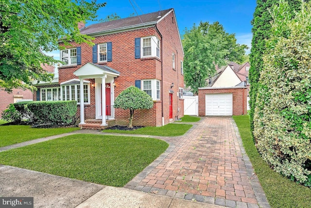 view of front of home featuring an outbuilding, a garage, and a front yard