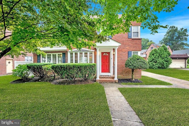 obstructed view of property with a front lawn