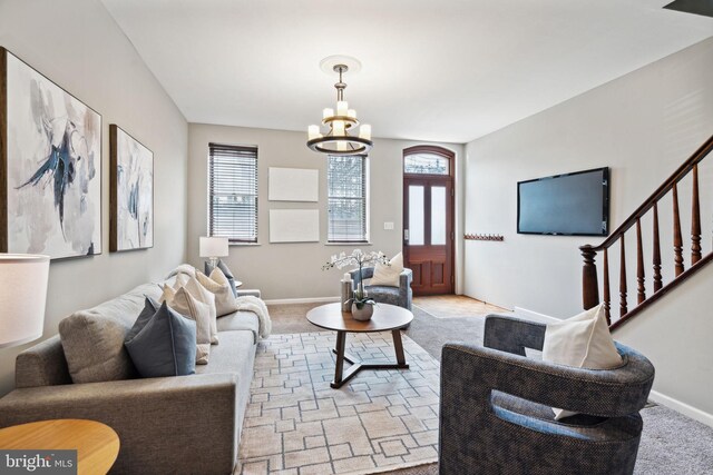 carpeted living room featuring a chandelier