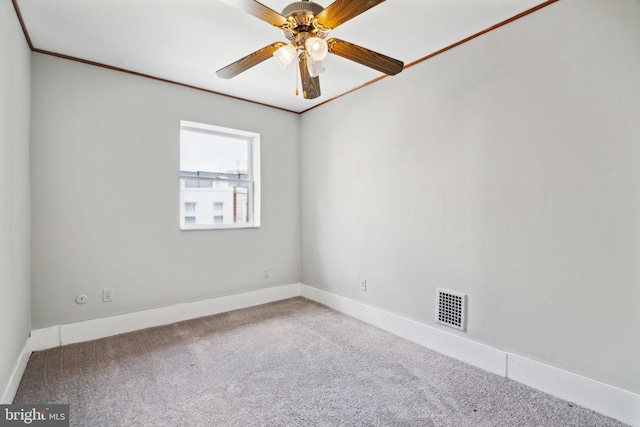 carpeted empty room featuring crown molding and ceiling fan