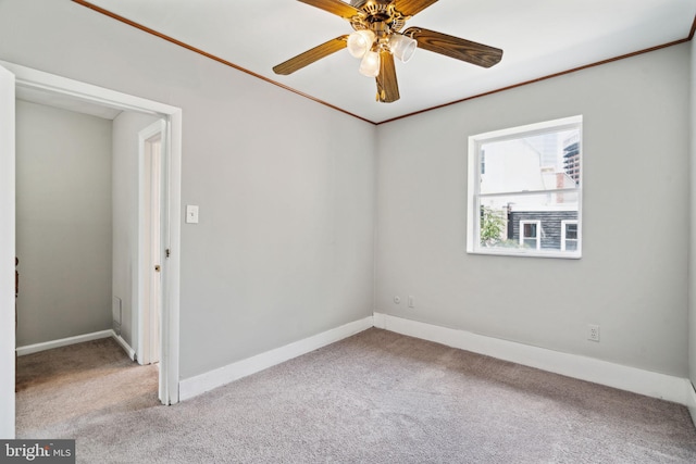 spare room with crown molding, carpet, and ceiling fan