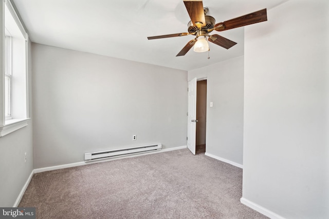 carpeted empty room featuring a baseboard heating unit and ceiling fan