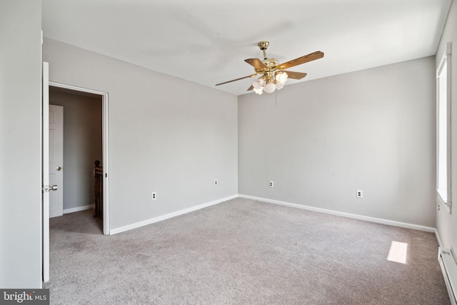 spare room with baseboard heating, light colored carpet, and ceiling fan