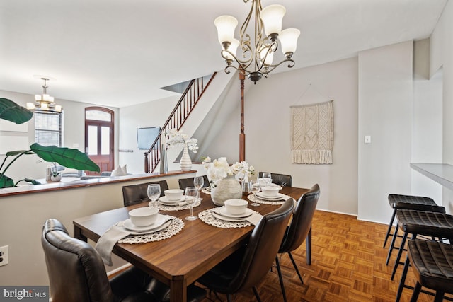 dining space with parquet floors and a chandelier