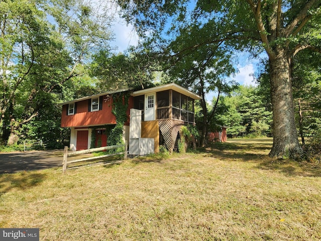 bi-level home featuring a garage, a sunroom, and a front yard