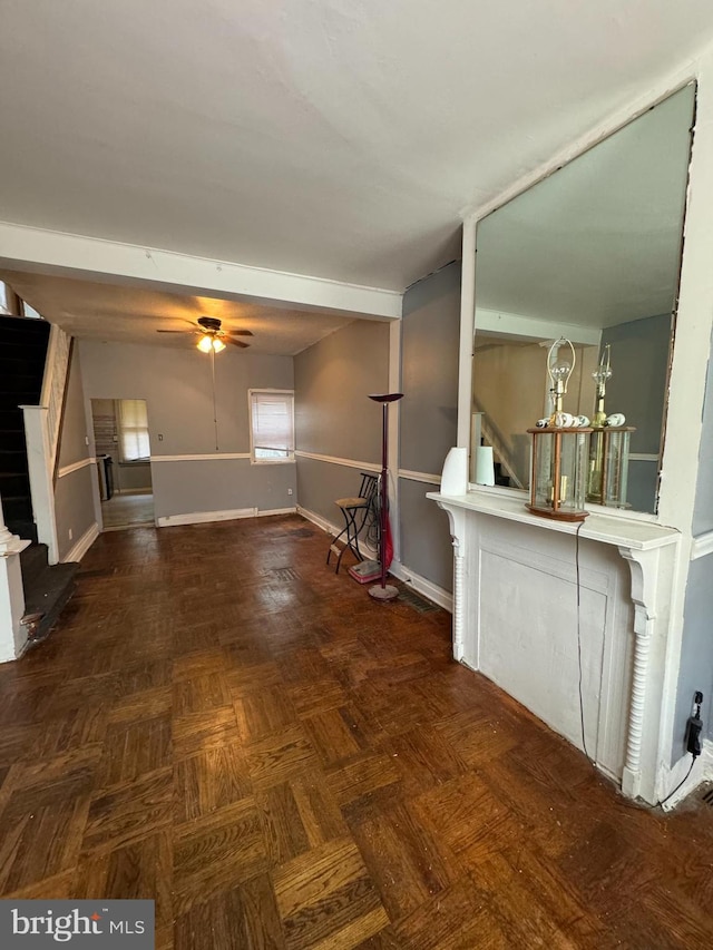 unfurnished living room featuring ceiling fan and parquet flooring