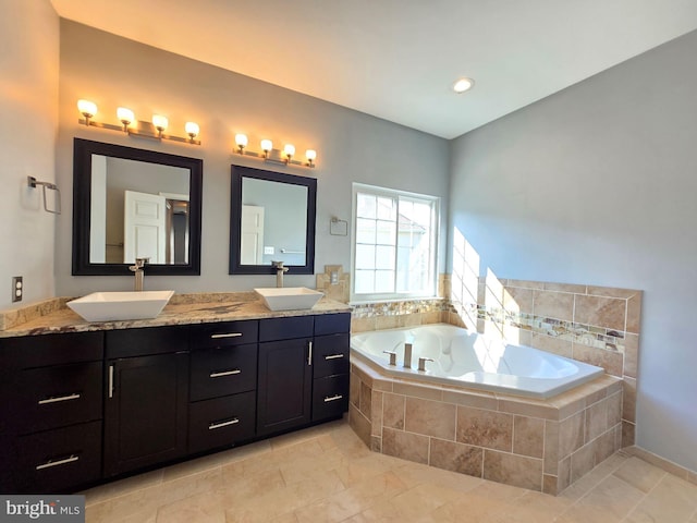 bathroom featuring vanity and a relaxing tiled tub