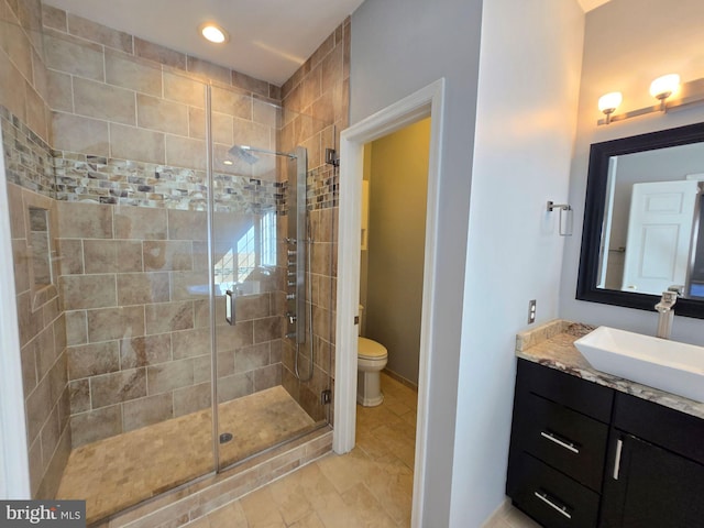 bathroom featuring vanity, an enclosed shower, and toilet