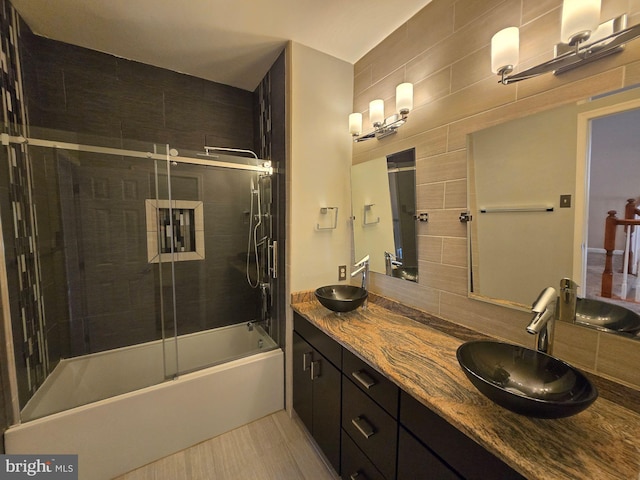 bathroom with tasteful backsplash, bath / shower combo with glass door, and vanity