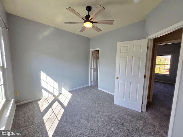 spare room with dark carpet and ceiling fan