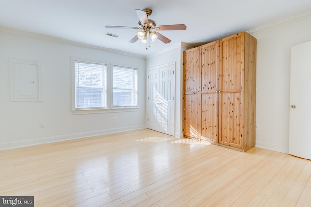 unfurnished bedroom featuring ceiling fan, electric panel, light hardwood / wood-style flooring, and ornamental molding