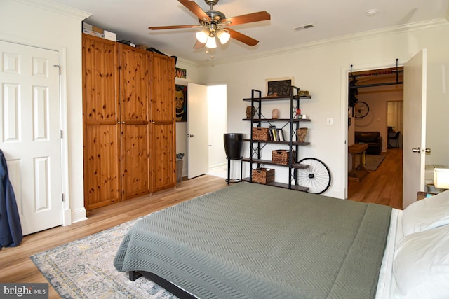 bedroom featuring ceiling fan, light hardwood / wood-style floors, and crown molding