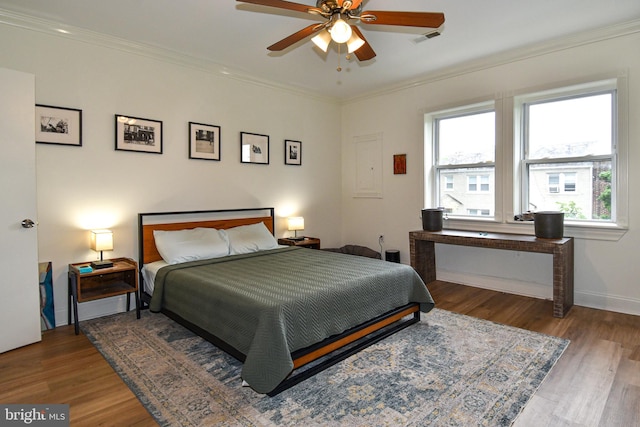 bedroom featuring ceiling fan, hardwood / wood-style flooring, and ornamental molding