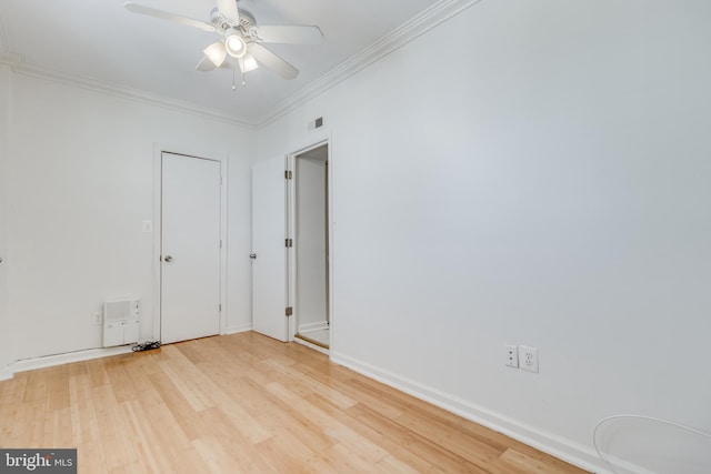 empty room featuring ceiling fan, light wood-type flooring, and crown molding