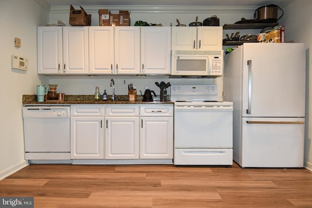 kitchen featuring white cabinetry, sink, dark stone counters, and white appliances