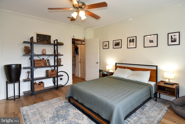 bedroom with ceiling fan, hardwood / wood-style flooring, a closet, and ornamental molding