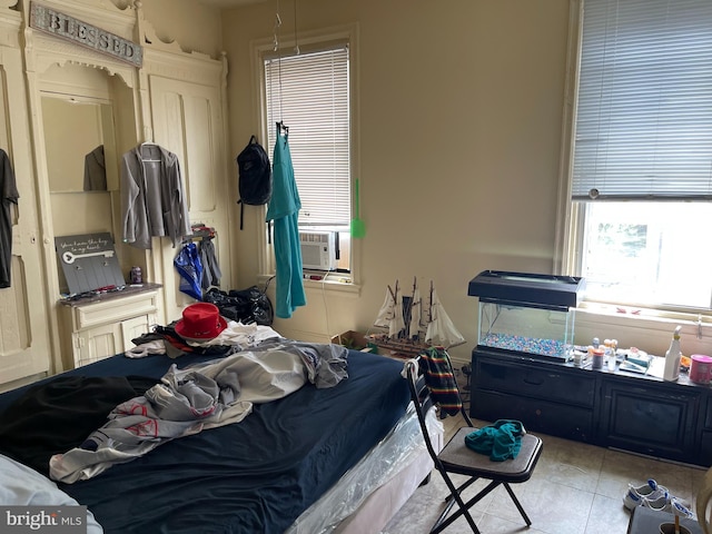 bedroom with cooling unit and light tile patterned floors