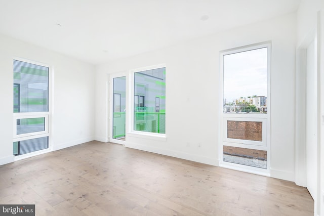 unfurnished room with light wood-type flooring and a healthy amount of sunlight