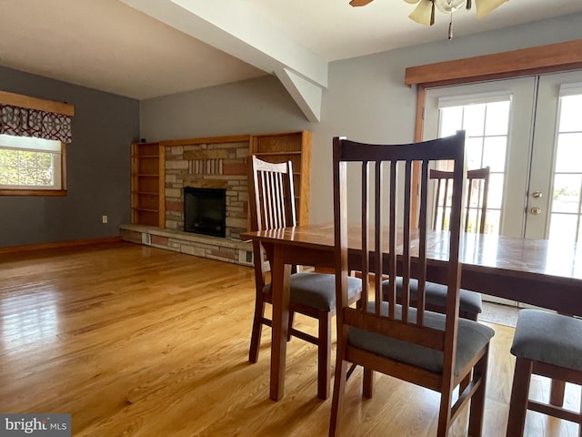 dining room featuring light hardwood / wood-style floors, a fireplace, and ceiling fan