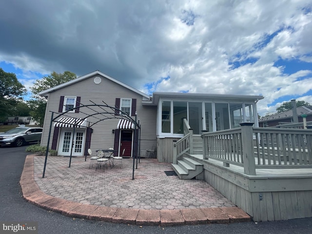 view of front of house with a wooden deck and a patio