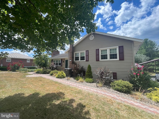 view of front of property with central AC and a front yard