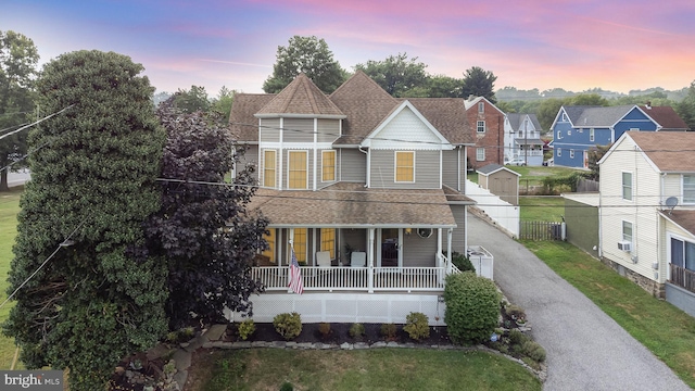 victorian house with central AC unit, a yard, and a porch