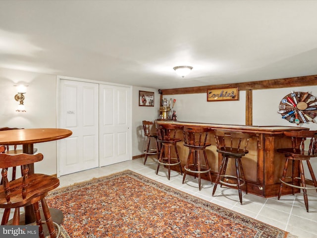 bar featuring a dry bar and light tile patterned floors