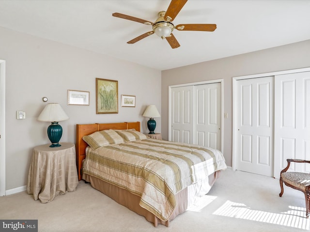 carpeted bedroom with baseboards, ceiling fan, and multiple closets