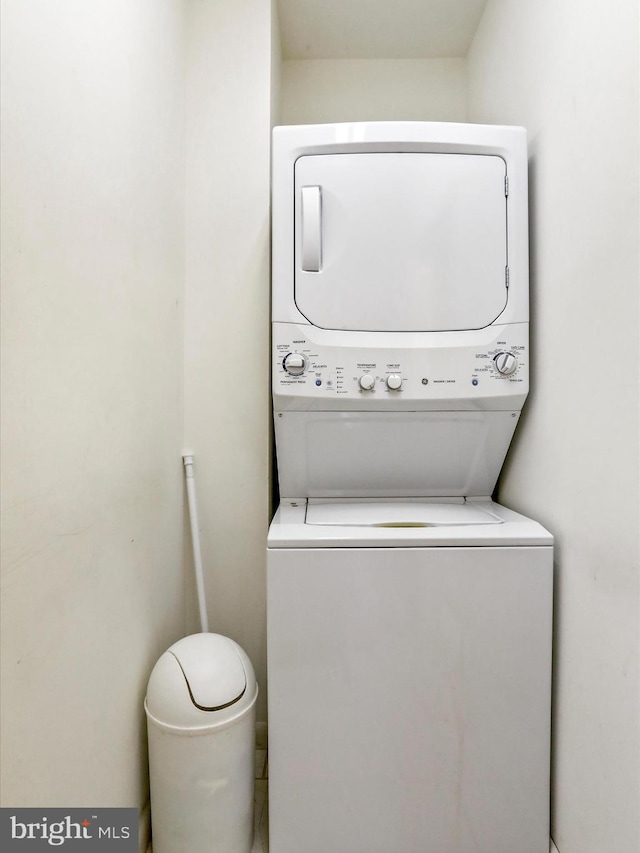 washroom featuring stacked washer and dryer and laundry area