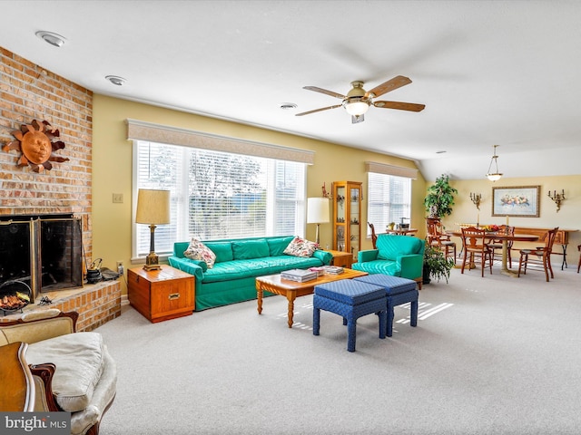 carpeted living room with a ceiling fan and a brick fireplace