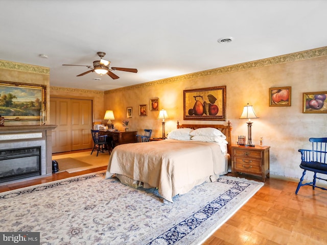 bedroom with visible vents, baseboards, and a glass covered fireplace