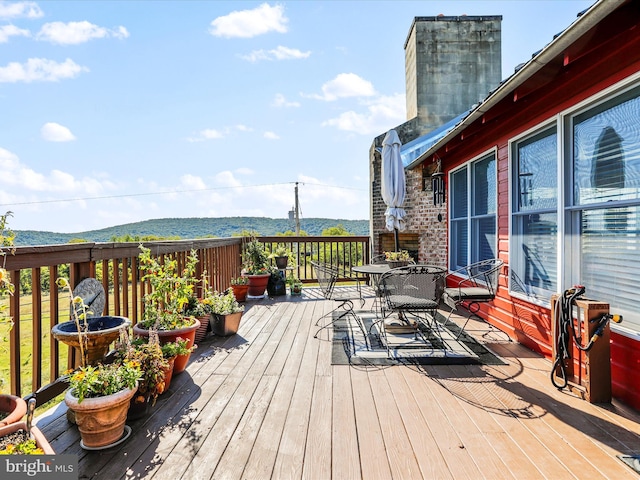 wooden terrace with a mountain view and outdoor dining area