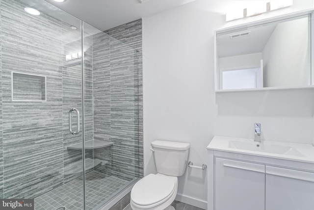 bathroom with vanity, toilet, and an enclosed shower