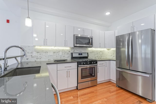 kitchen with stainless steel appliances, sink, and white cabinets