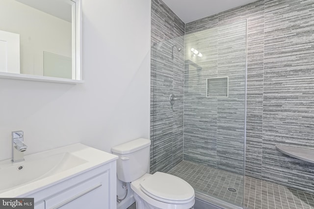 bathroom with walk in shower, vanity, and toilet