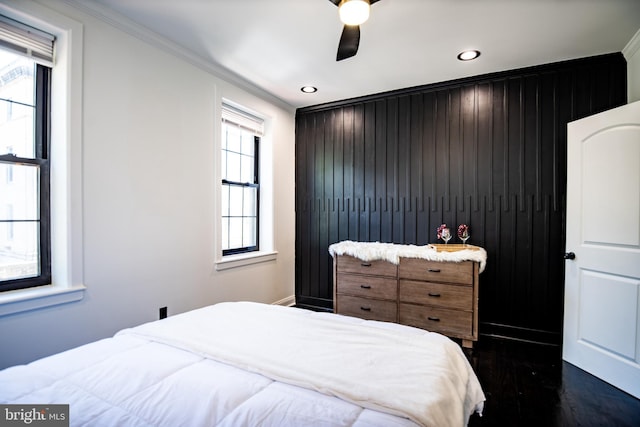 bedroom featuring ceiling fan, ornamental molding, dark hardwood / wood-style floors, and multiple windows