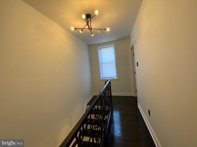 stairs featuring hardwood / wood-style floors and a chandelier