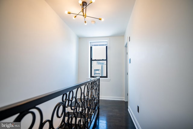 hall featuring a notable chandelier and dark hardwood / wood-style flooring